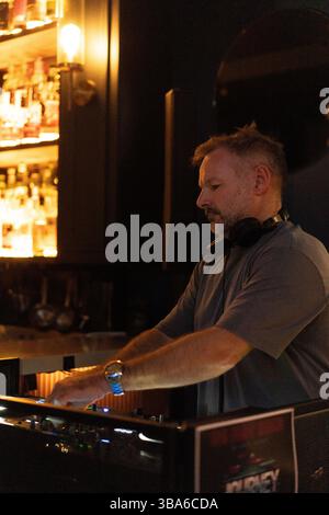 DJ amidst friends enjoying at nightclub Stock Photo