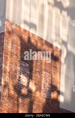 Historic Red Brick and beige rendered wall with architectural  shadows Stock Photo