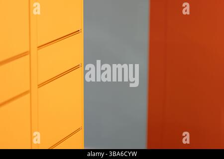 Colorful yellow cabinet creating abstract pattern on grey and red wall Stock Photo