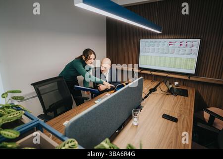 Business colleagues analyzing data collaboratively in a modern office environment Stock Photo
