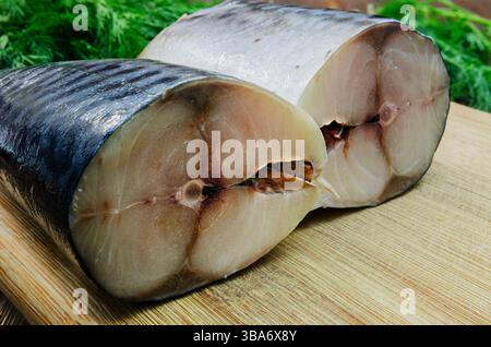 Close-up of freshly cut mackerel slices on a wooden cutting board, showcasing the fish's shiny skin and tender flesh. Stock Photo