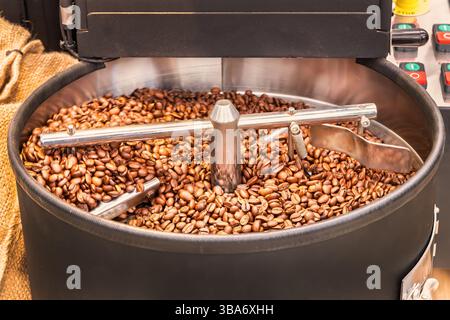 Grinding of fresh coffee beans in a professional coffee making machine Stock Photo
