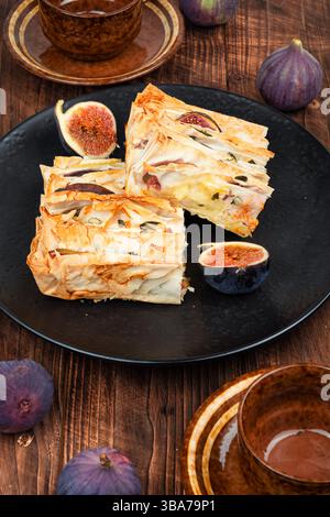 Freshly baked fig galette. Delicious tart with fresh figs and goat cheese on rustic wooden. Stock Photo