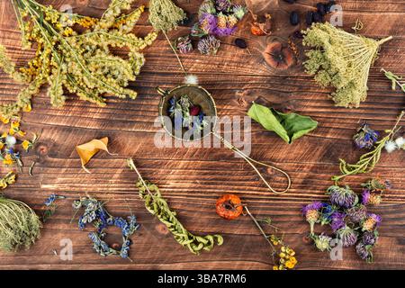Teapot, cup and medicinal herbs on rustic wooden table. Herbal medicine, tea time. Rustic style. Stock Photo