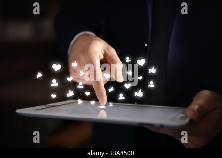 Man using tablet computer, closeup. Social media notifications flying out of device Stock Photo