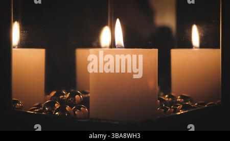 Christmas candle between mirrors on a stove Stock Photo