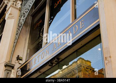 Golden signage reading "Royal Arcade" above a glass doorway, capturing elegance. Exterior of Barton Arcade, with the signage at the center. Stock Photo