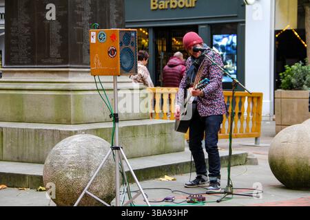 Street performer on Market Street, Manchester—capturing urban life and creative expression in the city centre. Stock Photo