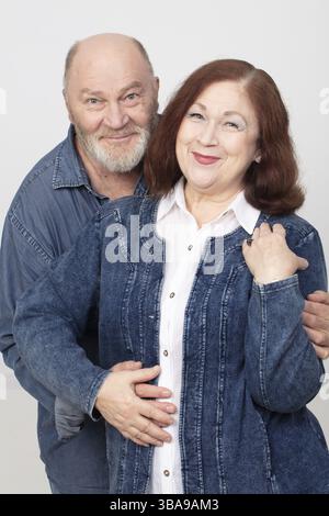 Portrait of an elderly, cheerful and amorous couple in denim clothing Stock Photo