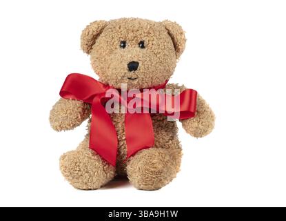 Toy fluffy vintage bear with a red bow on a white background. Brown teddy bear insulated Stock Photo