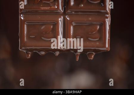Melted chocolate drips down on a brown background Stock Photo
