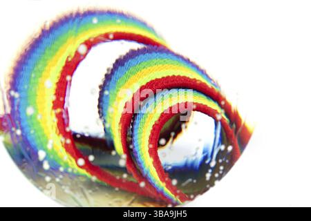 Optically abstract background made of rainbow fabric with creases and light effects in water droplets Stock Photo