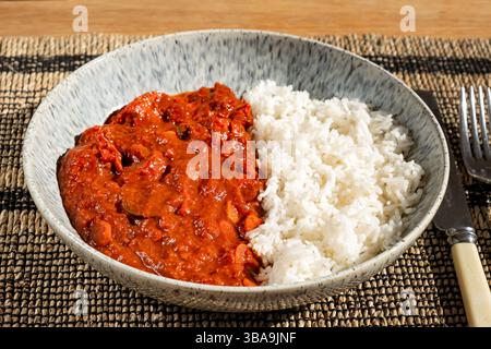 UK. A homemade chilli chicken curry served in a bowl with plain Basmati rice. Stock Photo