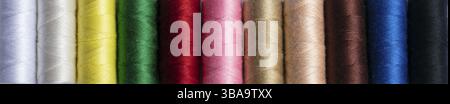Coloured sewing threads in a row for a banner. The texture of the multicoloured threads Stock Photo