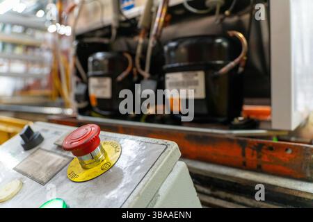 Emergency Stop installed at line conveyor in refrigerator manufacturing plant. START - STOP button for industrial machine. Industrial and factory conc Stock Photo