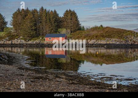 The Norwegian boathouse by the fjord in a Norwegian village on a beautiful Spring day. Stock Photo