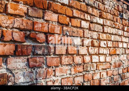 Old brickwork, side view. Potholes and defects in the brick wall. Flat view, close-up. Brick background Stock Photo