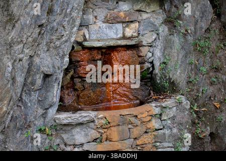 Rustic Stone Spring With Natural Water Flowing From a Rock Formation Stock Photo