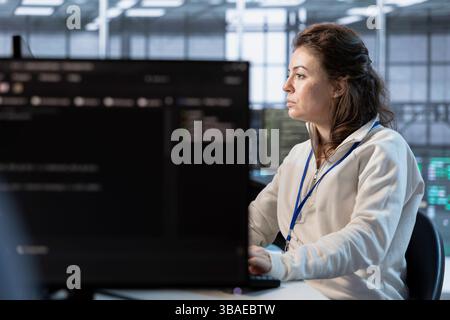 Computer scientist in server room implementing power management solutions to reduce energy consumption. Woman using PC, integrating new technologies and systems in data center Stock Photo