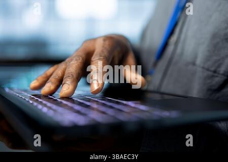 Admin in data center typing on notebook keyboard, using automation tools, doing predictive maintenance. Close up of IT specialist ensuring continuous uptime of server farm, managing data flows Stock Photo