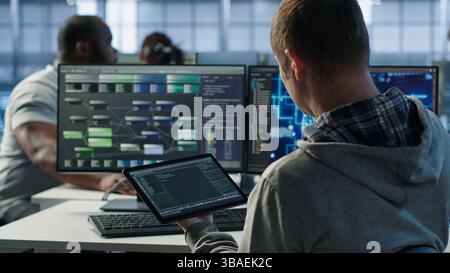 Computer scientist in data center uses artificial intelligence neural networks doing computing processes. IT specialist working on tablet with AI machine learning algorithms, camera A Stock Photo