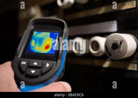 Inspect check of old electric screw fuse board panel for thermal heat with electrical thermography thermographic infrared camera imager Stock Photo