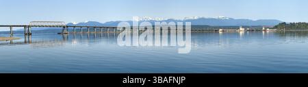 Wide panorama of Hood Canal Floating Bridge and Olympic Mountains under blue sky Stock Photo