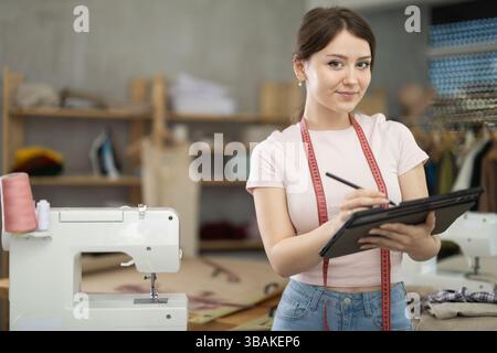 Woman dressmaker makes pattern using tablet Stock Photo