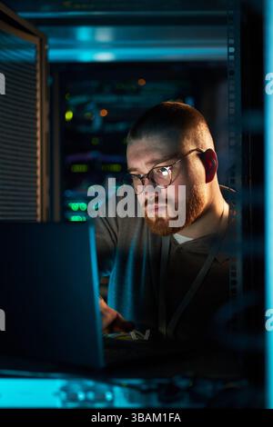 Working on Laptop in Data Center with Servers Stock Photo