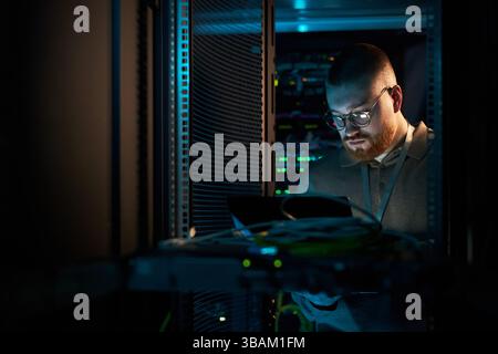 Technician Inspecting Server Hardware in Data Center Stock Photo