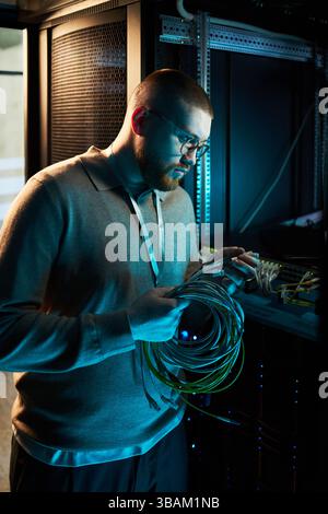 Technician Managing Server Cables in Data Center Stock Photo