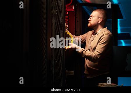 Technician Installing Network Cables in Server Room Stock Photo
