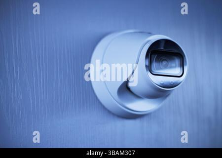 Modern Surveillance Camera Affixed on Wall Stock Photo