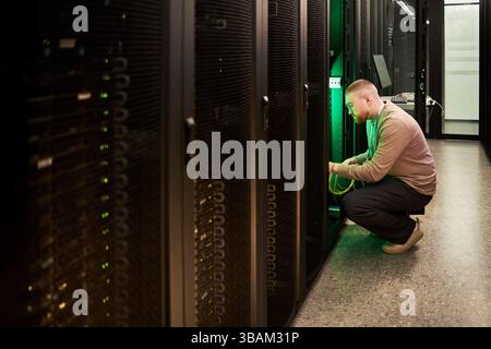 Technician Configuring Server Equipment in Data Center Stock Photo