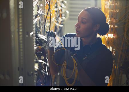 Technologist Working on Network Cables in Server Room Stock Photo