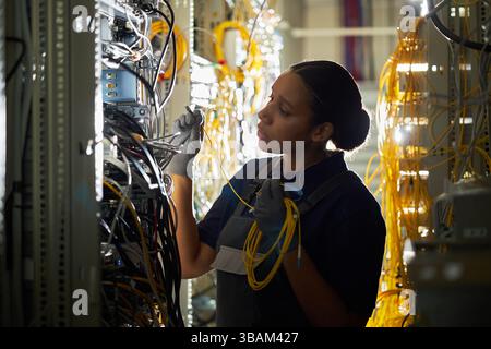Technician Configuring Network Cables in Server Room Stock Photo