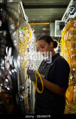 Technician Working on Server Room Cable Management Stock Photo