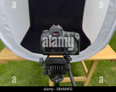 DSLR camera shooting toy tractor in portable light tent studio closeup view Stock Photo