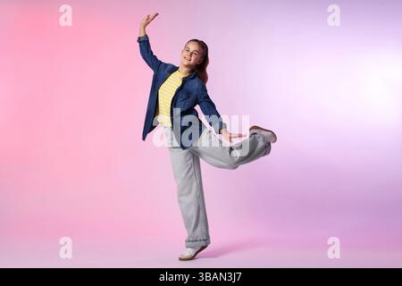 Girl in stylish clothes dancing on color background Stock Photo