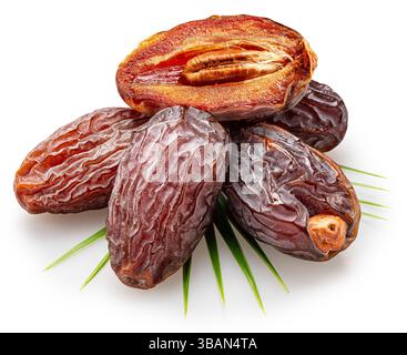 Semi-dried dates or date palm fruits lie on palm leaves isolated on white background. File contains clipping path. Stock Photo