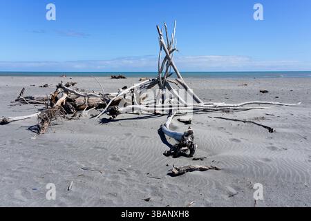 A stack of bleached driftwood on the grey sands of Hokitika beach. Stock Photo