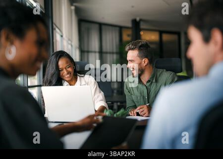 A diverse, talented team collaborates effectively in a bright office space during a business meeting Stock Photo