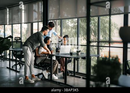 A diverse, talented team collaborates effectively in a bright office space during a business meeting Stock Photo