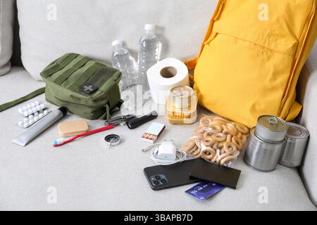 Survival kit. Different emergency supplies on sofa indoors Stock Photo