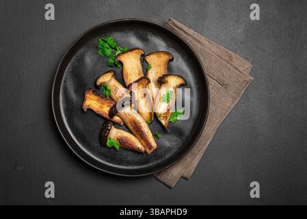King Oyster Mushroom Steak on black background, top view, copy space. Healthy vegan vegetarian food,  source of plant protein, Eryngii mushrooms Stock Photo