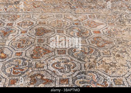 Roman mosaic flooring in Ephesus, with multicolored geometric patterns preserved in a luxurious home or bathhouse floor. Stock Photo