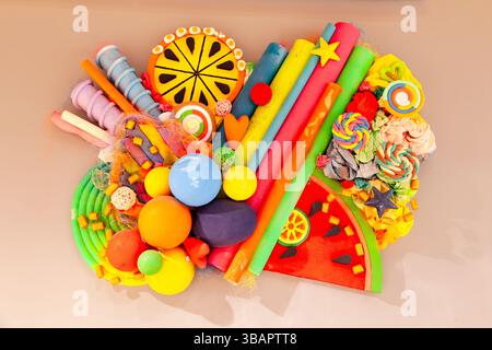 Colorful multicolored pattern on a pink wall made from various paper and plastic products. Stock Photo