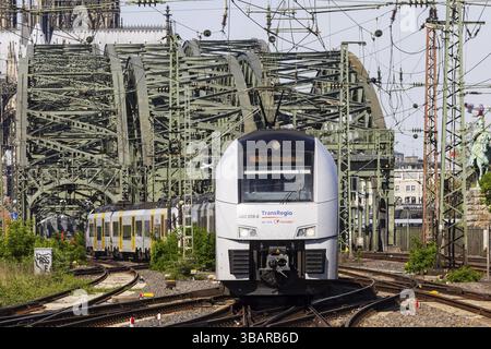 Rail traffic between Cologne-Deutz and Cologne Central Station. Hohenzollern Bridge, railway bridge over the Rhine. The towers of Cologne Cathedral in Stock Photo