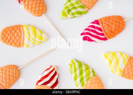 Vibrant and playful summer pattern made of ice cream shaped lollipops on white background. Creative candy concept. Colorful sweet food background. Stock Photo