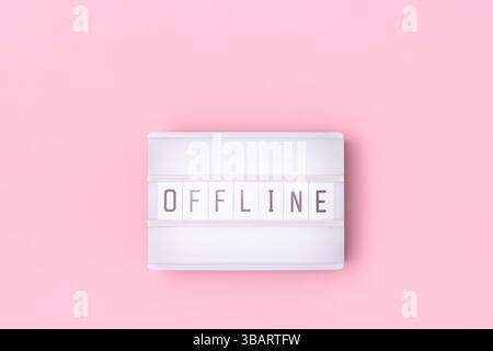 Word Offline. White lightbox with letters on a pink background. Stock Photo